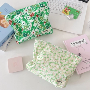 Detail of floral makeup pouches in green and sage colors with zipper and woven label
