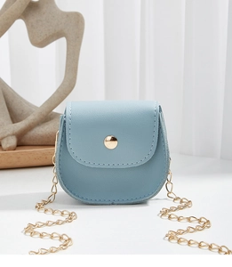 Close-up of light blue mini bag with golden metal buckle and delicate chain strap