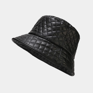 Detailed macro view of black faux leather bucket hat featuring quilted diamond patterns