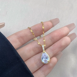 Detalle de collar de gota con gema pera y cadena dorada texturizada de estilo vintage