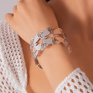 Detail of silver hollow butterfly cuff bracelet featuring intricate metal openwork patterns