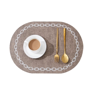Brown linen texture oval placemat with white chain pattern and golden cutlery