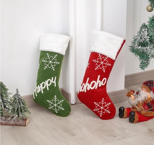 Close-up of plush Christmas stockings with Happy and Hohoho embroidery for festive decor