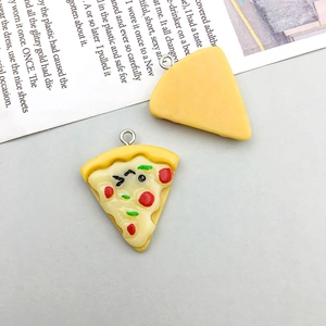 Close-up of cute cartoon pizza resin charms with smiley face details for DIY crafts