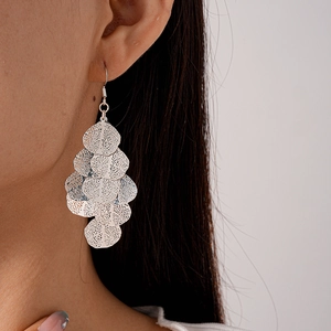 Close-up of silver hollow geometric leaf tassel earrings on model for a trendy look