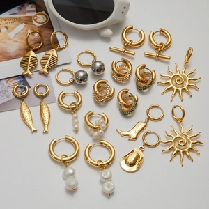 Collection d'élégantes boucles d'oreilles en acier doré avec perles et breloques
