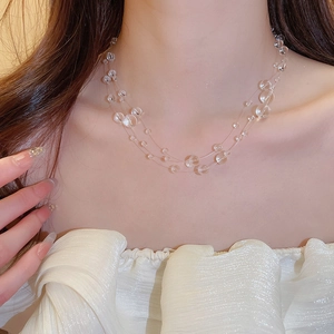 Close-up of triple-layered irregular clear bead necklace worn on model neck
