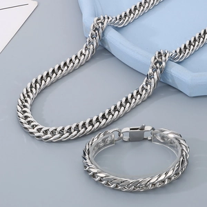 Detail view of silver stainless steel Cuban link necklace and bracelet set with woven texture