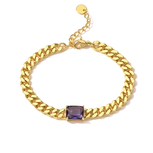 Detailed macro view of gold plated cuban link bracelet with purple zircon stone