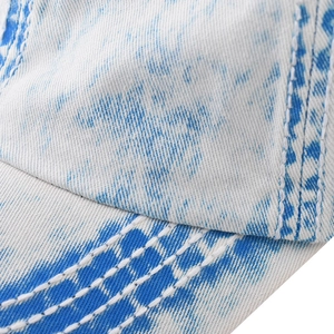Detail der weißen Doppelnaht an einer blau-weiß gewaschenen Denim-Baseballkappe