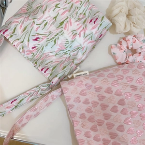 Detail of pink heart and floral embroidery on small canvas tote bags with simple wish label