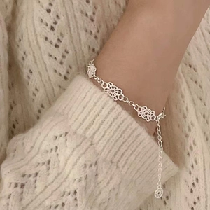 Elegant S925 sterling silver lace flower bracelet on wrist with soft knit sweater