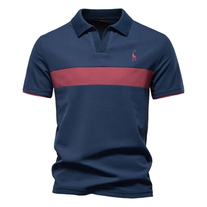 Detail of deer embroidery on navy polo shirt with red contrast stripes and pique cotton texture