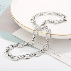 Collana a catena con maglie ovali in acciaio inossidabile argento su piatto bianco