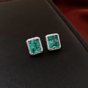 Close-up of square emerald stud earrings with micro-set white zircon borders
