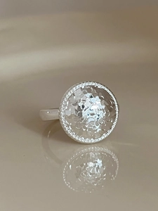 Macro view of a silver ring with a hammered texture and delicate beaded edge detailing