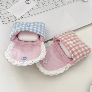 Close-up of fabric headphone case with lace trim and snap button on laptop keyboard