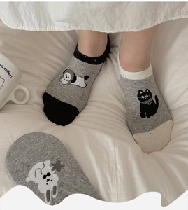 Close-up of gray cotton low-cut socks with cartoon cat embroidery on white fabric