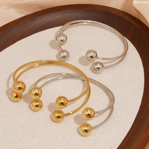 Minimalist stainless steel open bangle with metallic spheres in gold and silver finishes