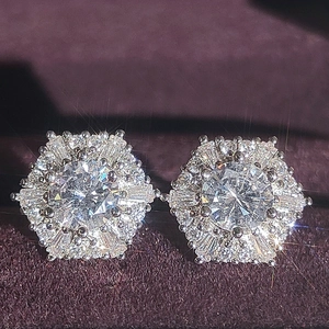 Hexagon silver stud earrings with sparkling white zircon stones on purple velvet