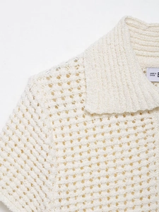 Gros plan du haut en crochet beige montrant les motifs ajourés et la texture du tricot
