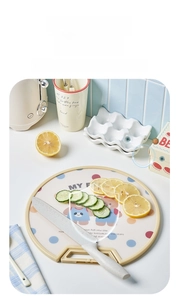 Close-up of semi-circular PP cutting board with handle and paring knife in a kitchen