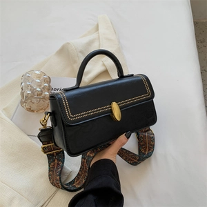 Vintage black leather crossbody bag with gold studs and patterned woven strap