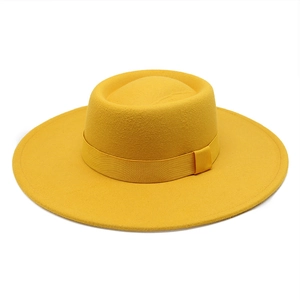 Detail view of ginger yellow wool felt fedora featuring flat top and wide brim design