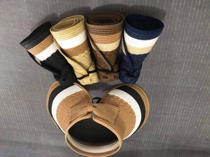 Top view of foldable straw sun hats in various colors showing breathable woven texture