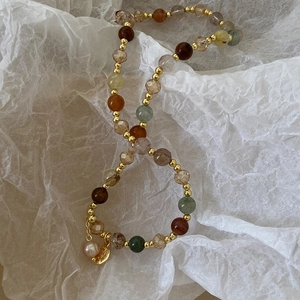 Detail of baroque pearl and portrait medal pendant on double layer beaded bracelet