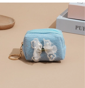 Close-up of light blue corduroy coin purse with lace bow and gold keychain ring