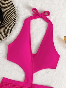 Détail d'un maillot de bain rose fuchsia à licou avec décolleté en V et bas à franges