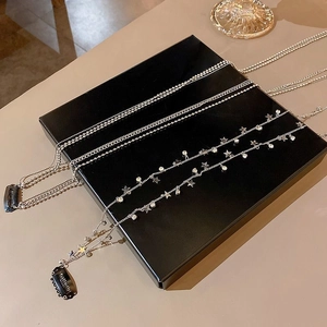 Detail of silver hair chain with sparkling star pendants and rhinestones on a black box