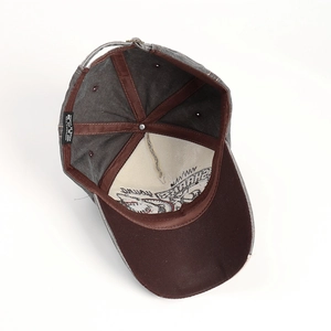 Detail of washed grey cotton baseball cap with shark embroidery and inner brown lining