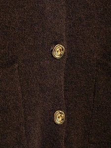 Macro shot of gold irregular buttons on dark brown wool knitted cardigan detail