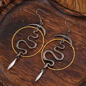 Macro detail of gothic snake earrings in antique silver and gold crescent moon design