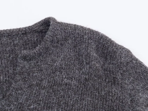 Detailed close-up of dark grey mohair blend knit fabric texture and soft crew neckline