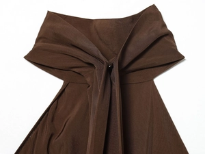 Λεπτομέρεια καφέ εξώπλατης μπλούζας με υφή twill υφάσματος και κόμπο με κουμπί στο κέντρο