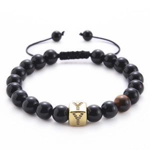 Detailed macro view of black onyx beads and golden micro-pave zircon letter Y bead on bracelet