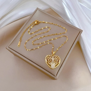 Elegant gold-plated heart necklace with tree of life pendant on white silk fabric