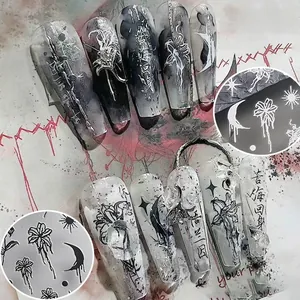 Detail of gothic nail stickers with gold lily hearts and artistic Chinese characters