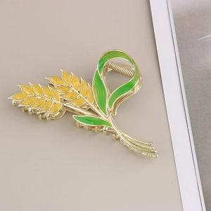 Détail d'une élégante pince à cheveux épis de blé dorée avec émail jaune et vert