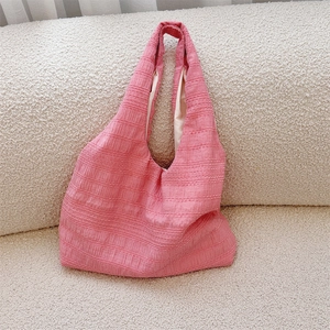 Detail of pink tote bag with vertical pleated texture and soft fabric material