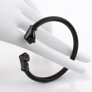 Close-up of black twisted cable cuff bracelet featuring detailed double fist end caps