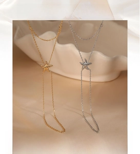 Detailed view of dual-layer starfish hand chain in gold and silver on wave display