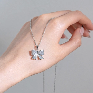 Collier élégant avec pendentif nœud argenté et oxydes de zirconium scintillants
