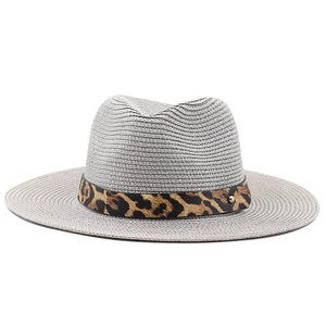 Detailed texture of grey woven straw fedora hat with leopard print band and gold buckle