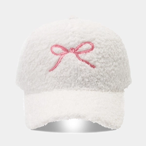Close-up of white lamb wool texture and pink bow embroidery on the baseball cap