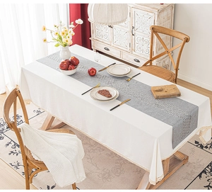 Close-up of grey cut-out pattern table runner on white cloth for home dining decoration