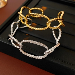 Detail of gold and silver irregular oval bangle with twisted industrial texture